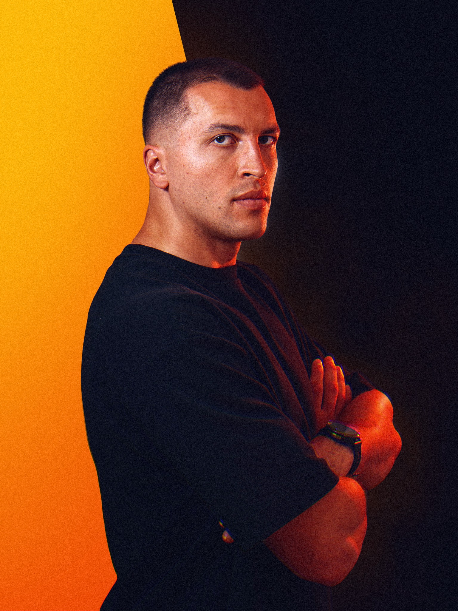 Slava, sports graphic designer and educator, against an amber and dark background